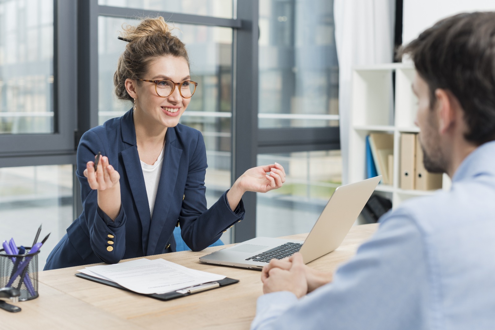Conseillère Assur'Njoy en rendez-vous avec un client dans un bureau lumineux